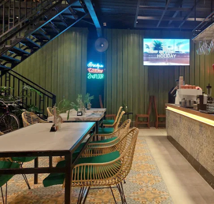 restaurant dining area with tables, green chairs, and service counter