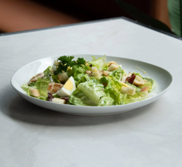green salad bowl photographed on a dining table